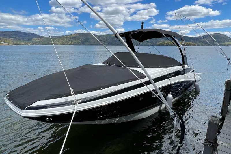 The Image of 2023 Crownline Eclipse E255 boat docked on a scenic lake with mountains. - 0
