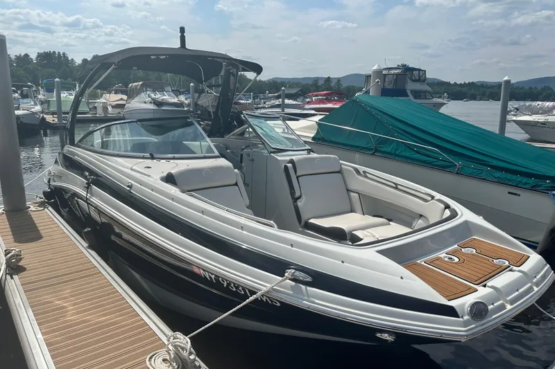 Slide: The Image of 2023 Crownline Eclipse E255 boat on trailer, black and white design, parked outdoors. - 12
