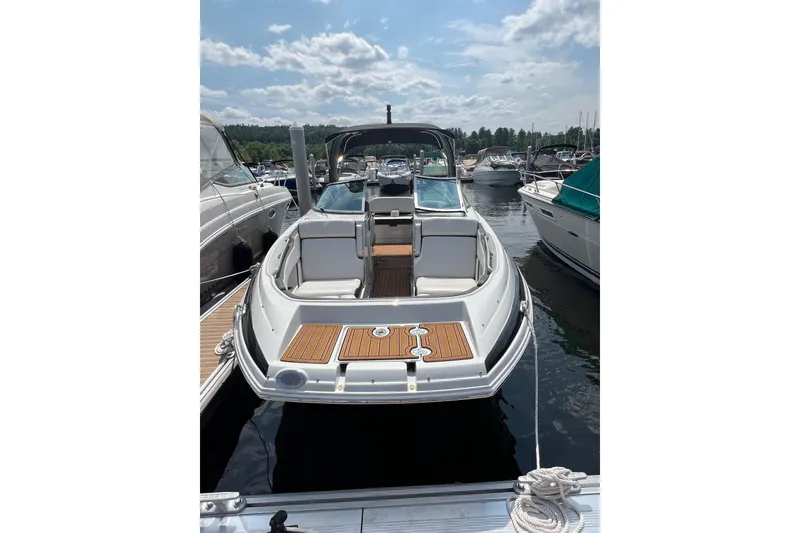 Slide: The Image of 2023 Crownline Eclipse E255 boat docked at marina under a partly cloudy sky. - 3