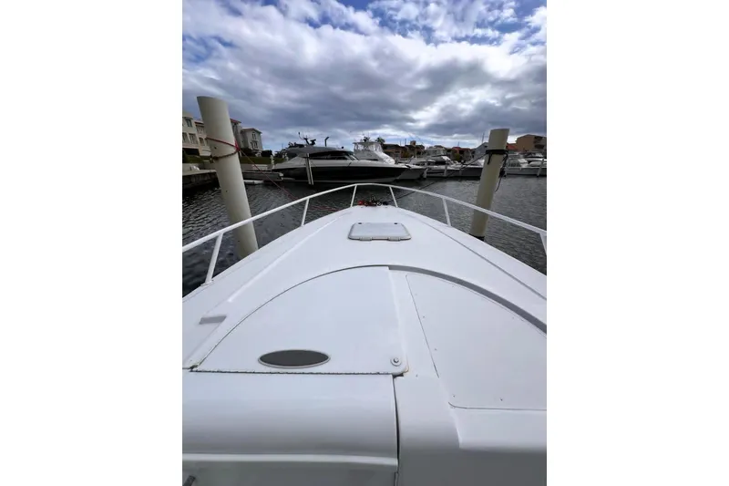 Slide: The Image of 1996 Itrepid 35 Cuddy boat docked in a marina under cloudy skies. - 12