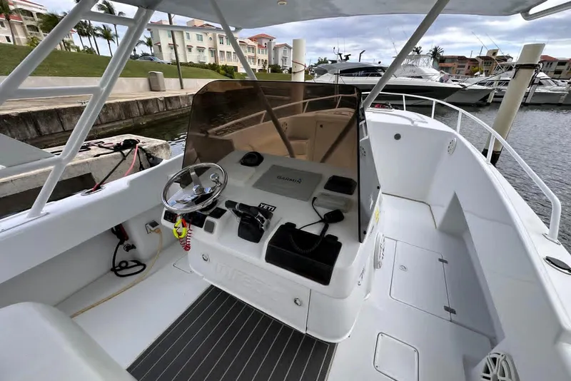 Slide: The Image of 1996 Itrepid 35 Cuddy boat interior with steering wheel and docked marina view. - 3