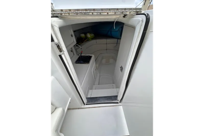 Slide: The Image of 1996 Itrepid 35 Cuddy cabin interior with white seating and compact design. - 5