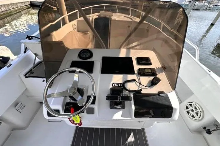 Slide: The Image of 1996 Itrepid 35 Cuddy boat helm with steering wheel, navigation instruments, and marina background. - 9