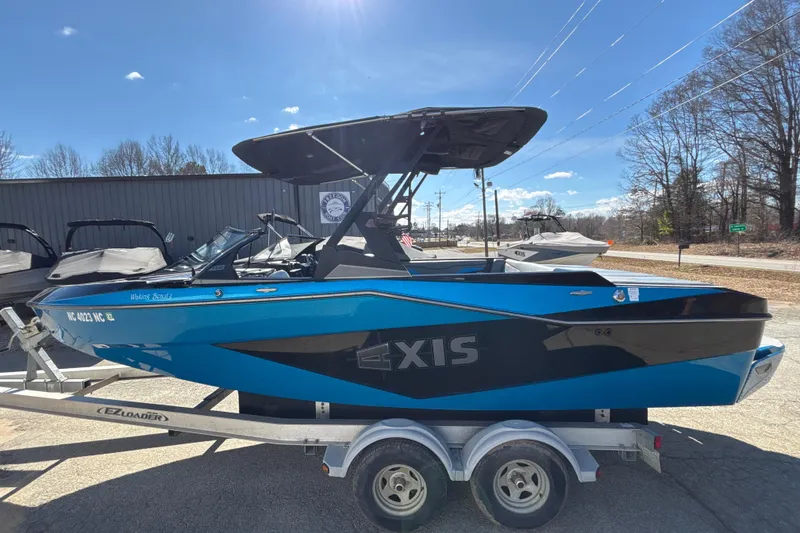 Slide: The Image of 2023 Axis T220 boat in blue on trailer, sunny day, outdoor display. - 10