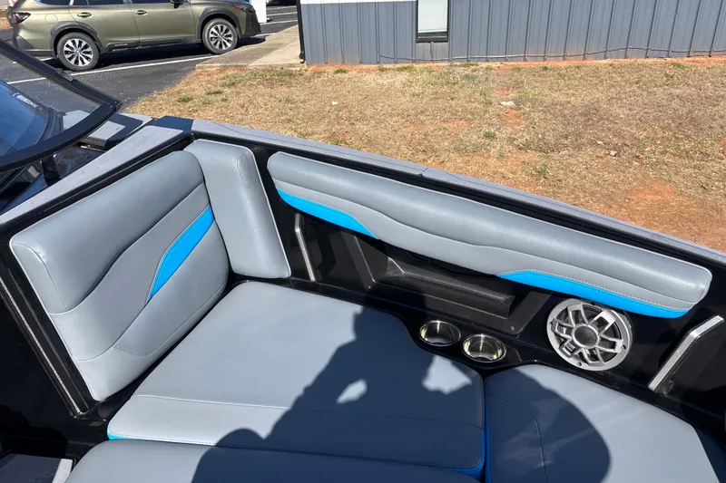 Slide: The Image of 2023 Axis T220 boat interior with gray and blue seating, speaker, and cup holders. - 15