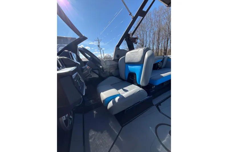 Slide: The Image of 2023 Axis T220 boat interior with blue and gray seating under clear sky. - 20