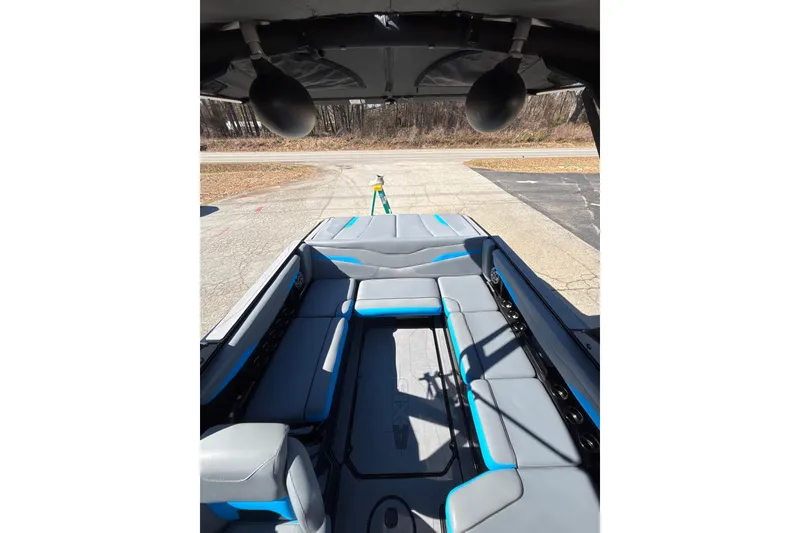 Slide: The Image of 2023 Axis T220 boat interior with gray and blue seating, outdoor setting. - 21