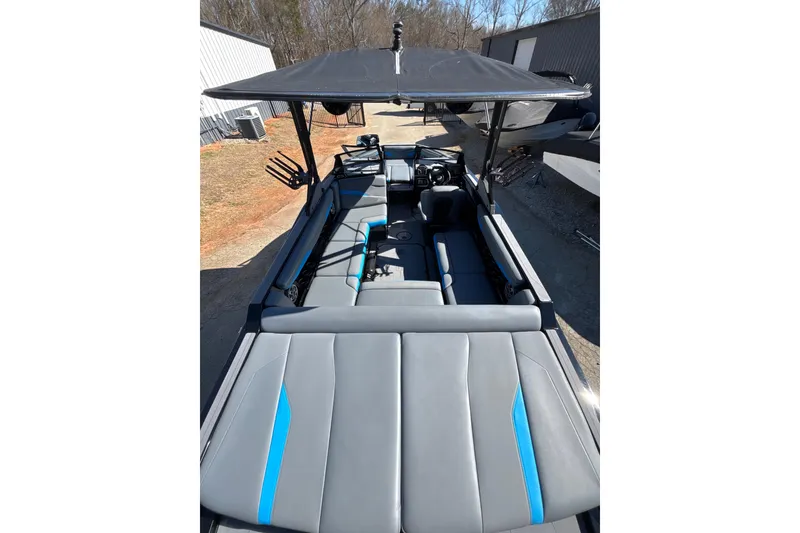 Slide: The Image of 2023 Axis T220 boat interior with gray and blue seating, under a canopy. - 24