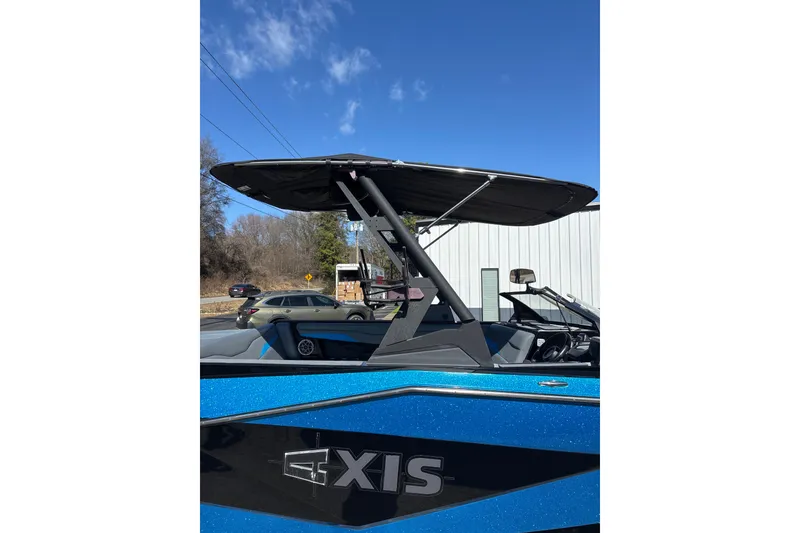 Slide: The Image of 2023 Axis T220 boat with blue exterior and black canopy under clear sky. - 4