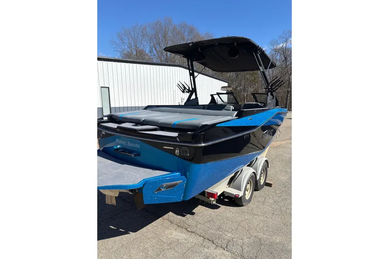 Slide: The Image of 2023 Axis T220 boat in blue and black on a trailer, outdoors. - 6