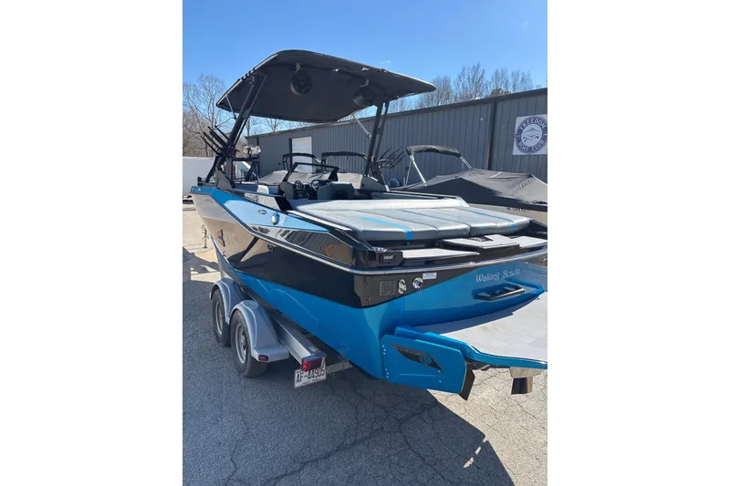 Slide: The Image of 2023 Axis T220 boat on trailer, blue and black design, parked outdoors. - 8