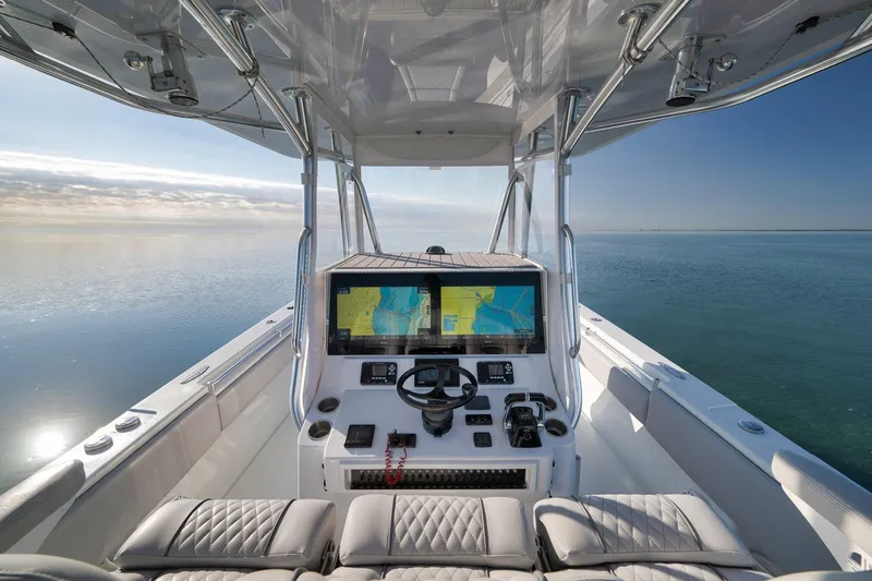 Slide: The Image of 2021 Contender 39 ST boat cockpit with navigation screens on calm water. - 18