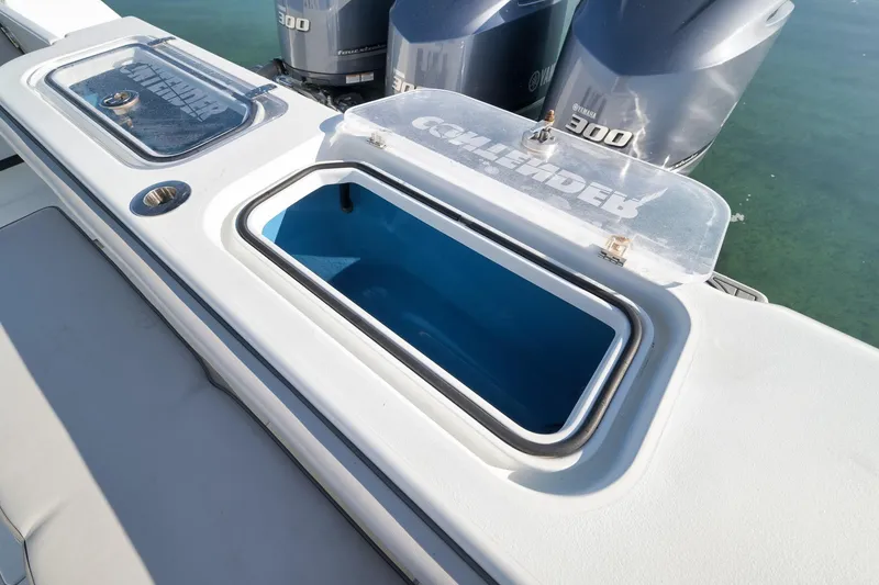 Slide: The Image of 2021 Contender 39 ST boat with open storage compartment and Yamaha 300 engines. - 25