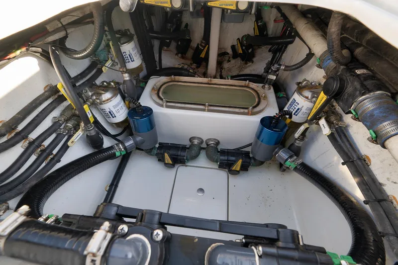 Slide: The Image of Engine compartment of a 2021 Contender 39 ST boat, showcasing fuel filters and hoses. - 27