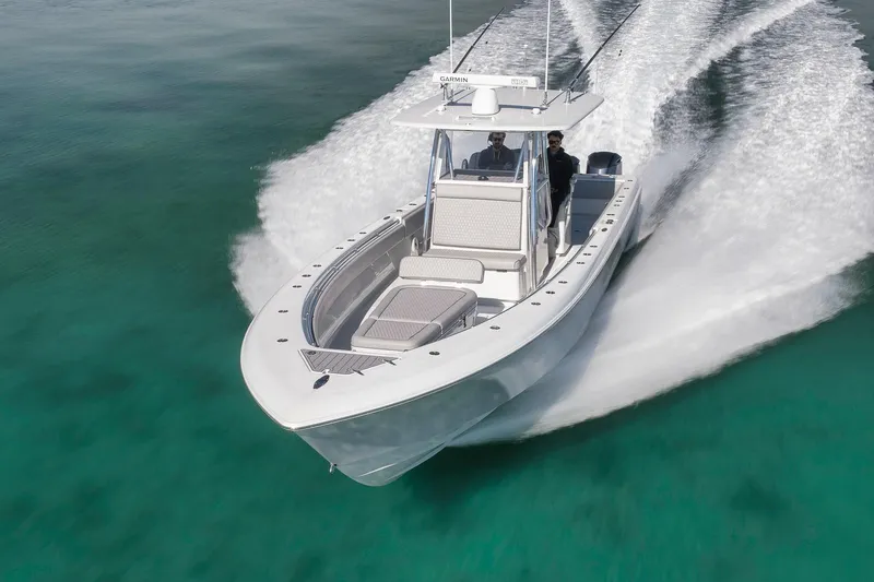 Slide: The Image of 2021 Contender 39 ST boat cruising on clear turquoise water. - 8