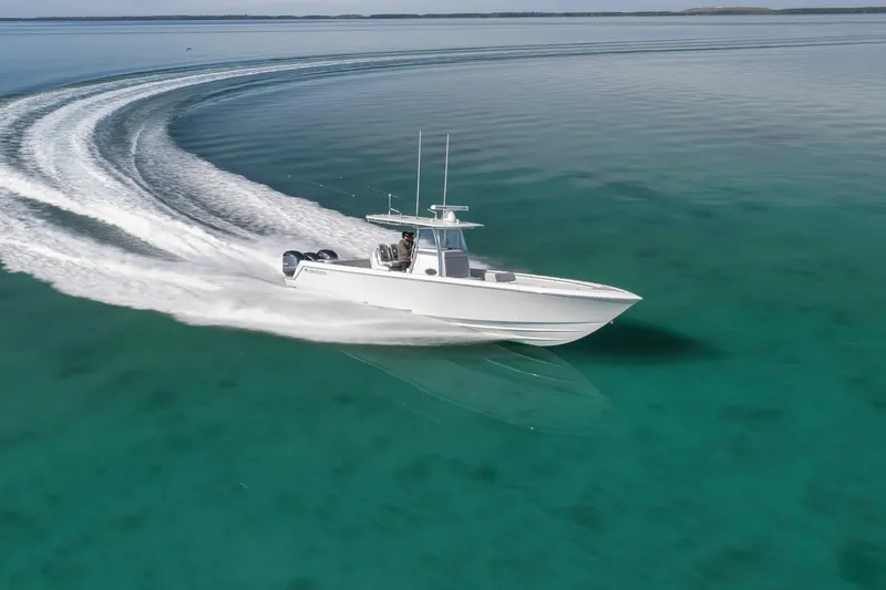 Slide: The Image of 2021 Contender 39 ST boat cruising on clear turquoise water. - 9