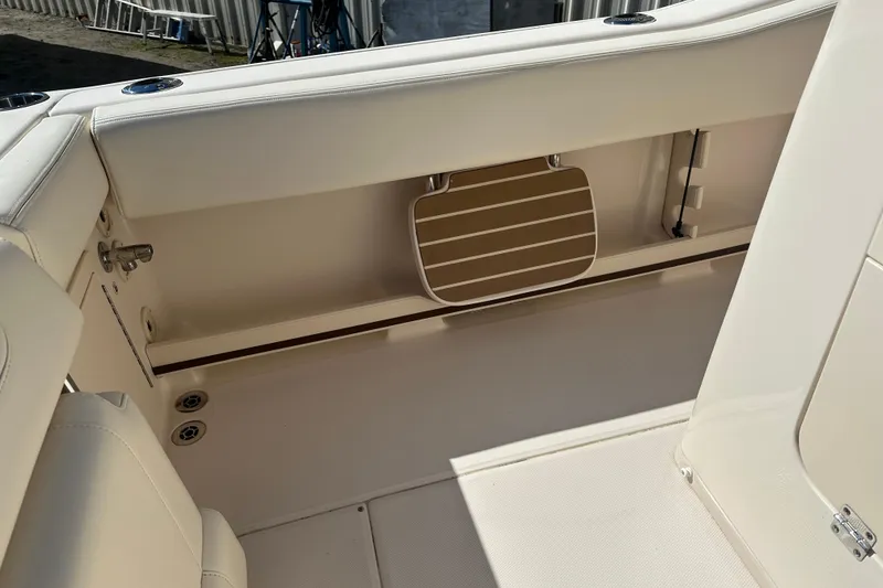 Slide: The Image of 2023 Grady-White Fisherman 257 boat interior with beige seating and storage compartment. - 15