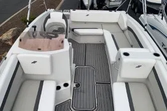 Slide: The Image of 2023 Starcraft SVX 171 OB boat interior with white seating and gray flooring. - 3