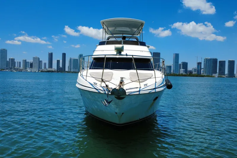 Slide: The Image of 2004 Carver 444 Cockpit Motor Yacht on water with city skyline backdrop. - 11