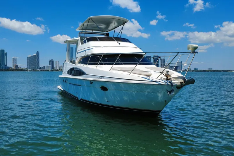 Slide: The Image of 2004 Carver 444 Cockpit Motor Yacht on water with skyline backdrop. - 12