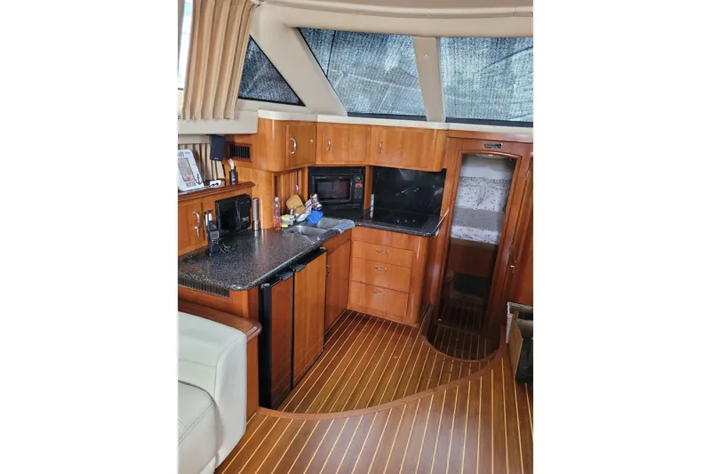 Slide: The Image of 2004 Carver 444 Cockpit Motor Yacht interior with wood cabinetry and modern amenities. - 4