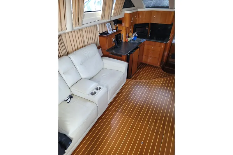 Slide: The Image of Luxurious interior of 2004 Carver 444 Cockpit Motor Yacht with leather seating and wood flooring. - 5