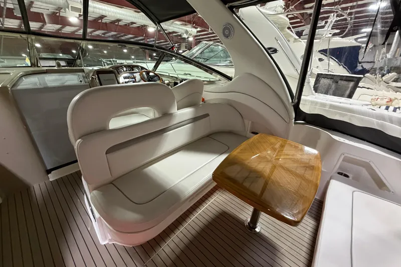 Slide: The Image of 2005 Sea Ray 360 Sundancer interior with white seating and wooden table. - 17