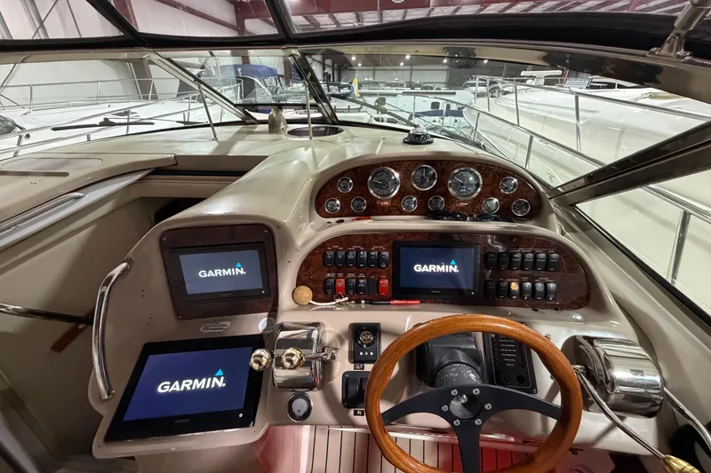 Slide: The Image of 2005 Sea Ray 360 Sundancer helm with Garmin navigation displays and wooden steering wheel. - 23