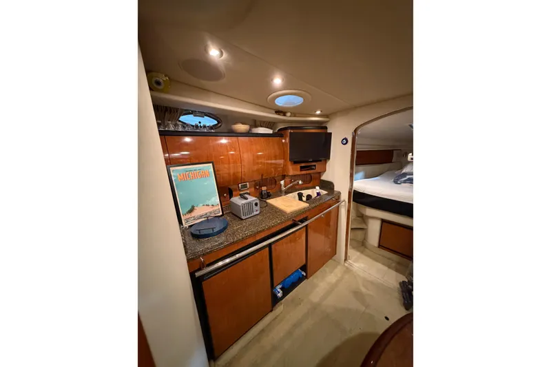 Slide: The Image of 2005 Sea Ray 360 Sundancer interior with kitchenette and cozy sleeping area. - 33