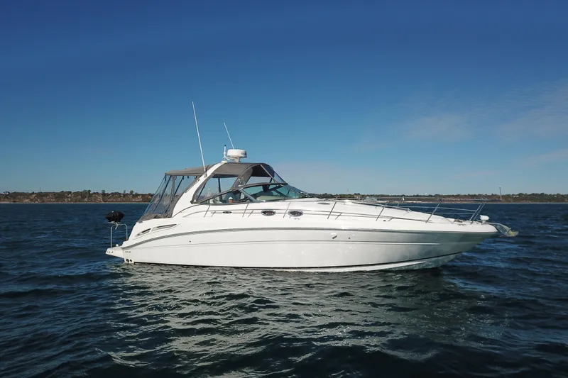 Slide: The Image of 2005 Sea Ray 360 Sundancer yacht on open water under clear blue sky. - 8
