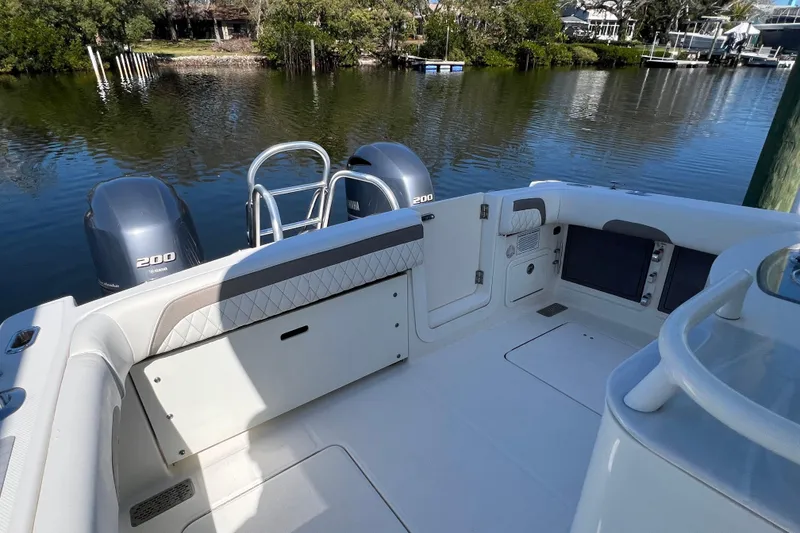 Slide: The Image of 2022 World Cat 280 CC-X boat interior with Yamaha 200 engines, docked by a serene waterfront. - 11