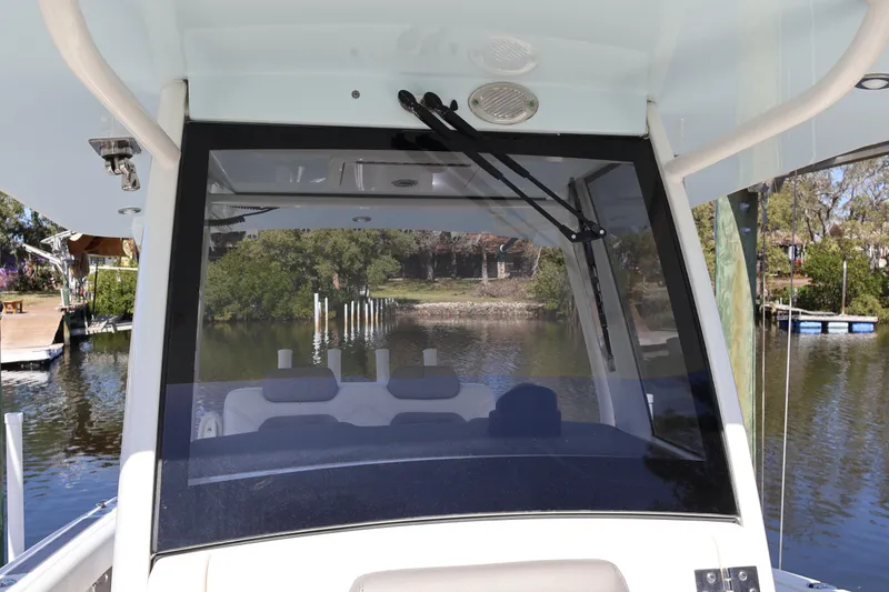 Slide: The Image of 2022 World Cat 280 CC-X boat windshield view with scenic waterway background. - 49