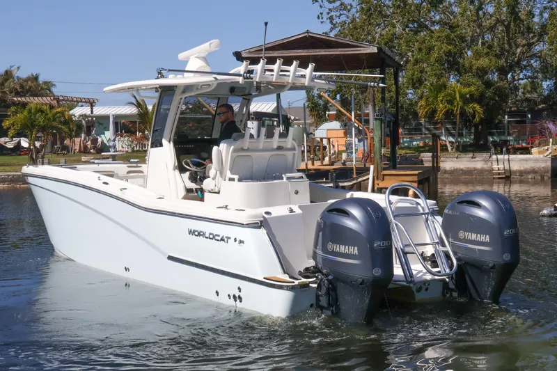 Slide: The Image of 2022 World Cat 280 CC-X boat with dual Yamaha engines on a calm waterway. - 7
