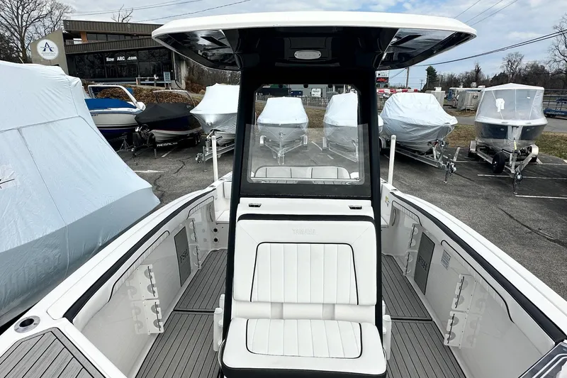 Slide: The Image of 2023 Yamaha Boats 255 FSH Sport E, sleek design, parked among covered boats. - 25