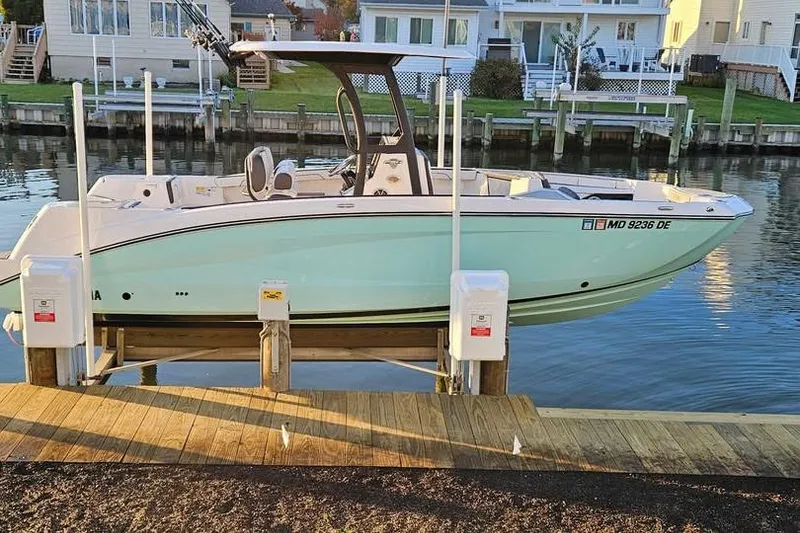 Slide: The Image of 2023 Yamaha Boats 255 FSH Sport E on trailer, parked in residential area. - 3