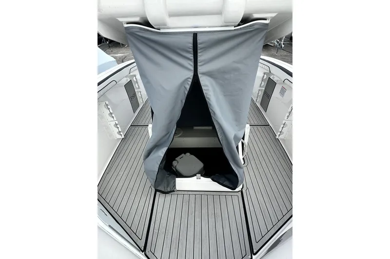 Slide: The Image of 2023 Yamaha Boats 255 FSH Sport E interior with gray cover and deck flooring. - 31