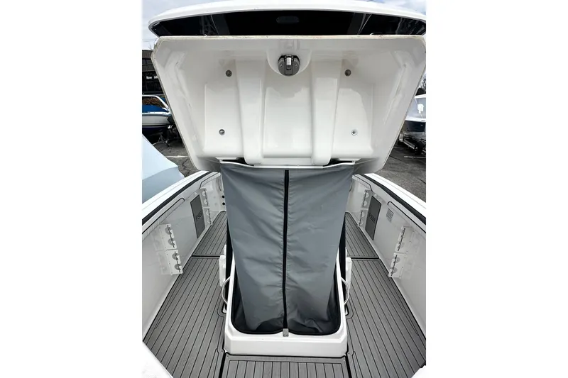 Slide: The Image of 2023 Yamaha Boats 255 FSH Sport E, open storage compartment, gray interior, sleek design. - 32