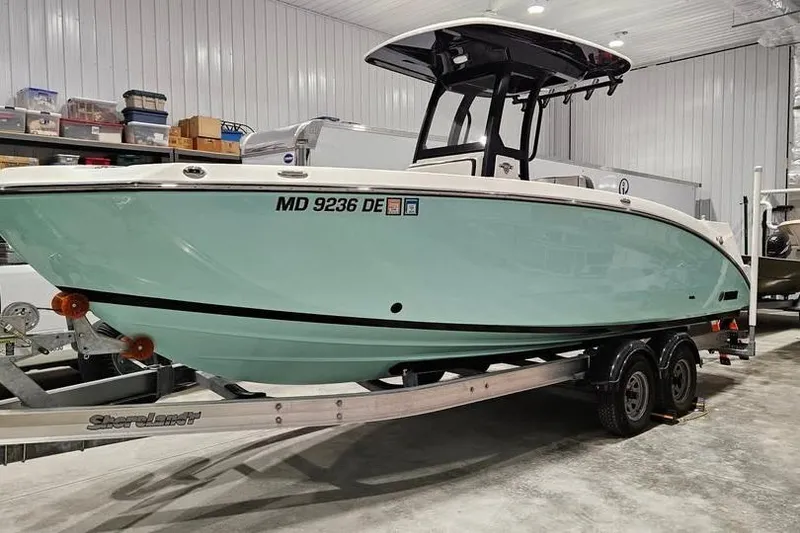 Slide: The Image of 2023 Yamaha Boats 255 FSH Sport E docked in calm waters. - 6