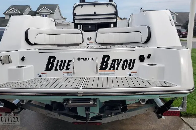 Slide: The Image of 2023 Yamaha Boats 255 FSH Sport E docked in a scenic marina setting. - 8