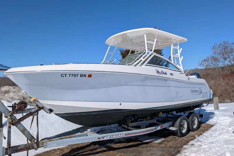 The Image of 2021 Robalo R247 Dual Console boat on trailer in snowy landscape. - 0