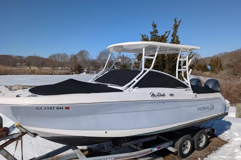 Slide: The Image of 2021 Robalo R247 Dual Console boat on trailer in snowy landscape. - 1
