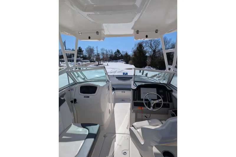 Slide: The Image of 2021 Robalo R247 Dual Console boat interior with helm, seating, and clear sky view. - 14