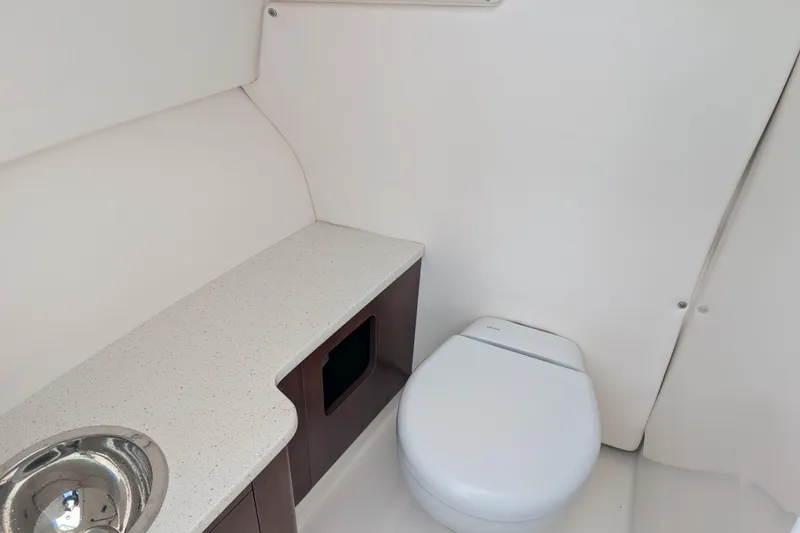 Slide: The Image of 2021 Robalo R247 Dual Console boat interior with toilet and sink. - 20
