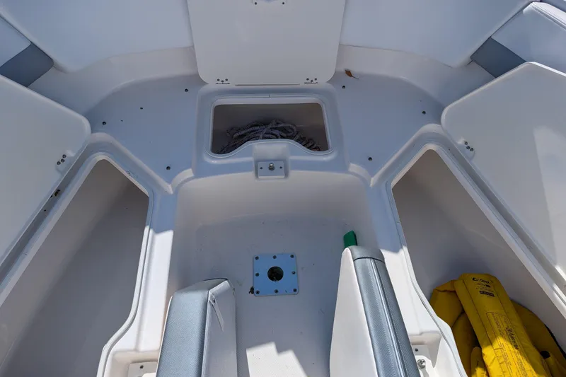 Slide: The Image of 2021 Robalo R247 Dual Console boat interior with storage compartments and seating. - 24