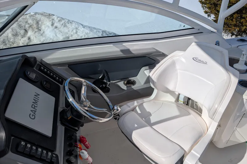 Slide: The Image of 2021 Robalo R247 Dual Console boat interior with Garmin navigation and white captain's chair. - 25