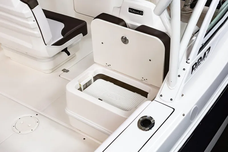 Slide: The Image of Manufacturer Provided Image: 2021 Robalo R247 Dual Console boat interior with storage compartment open. - 30