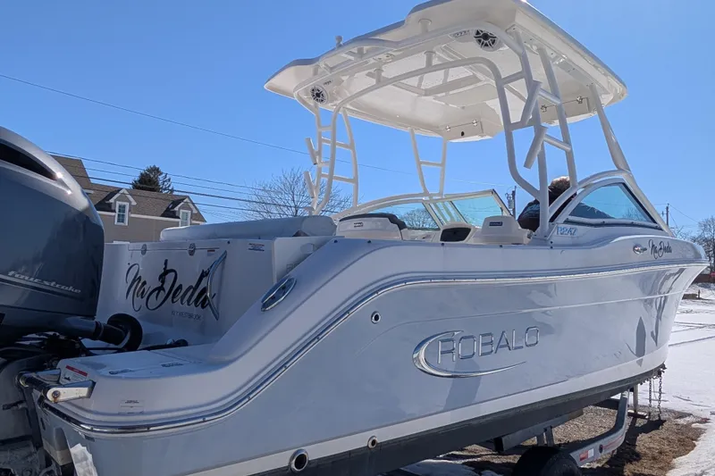 Slide: The Image of 2021 Robalo R247 Dual Console boat on trailer, under clear blue sky. - 4