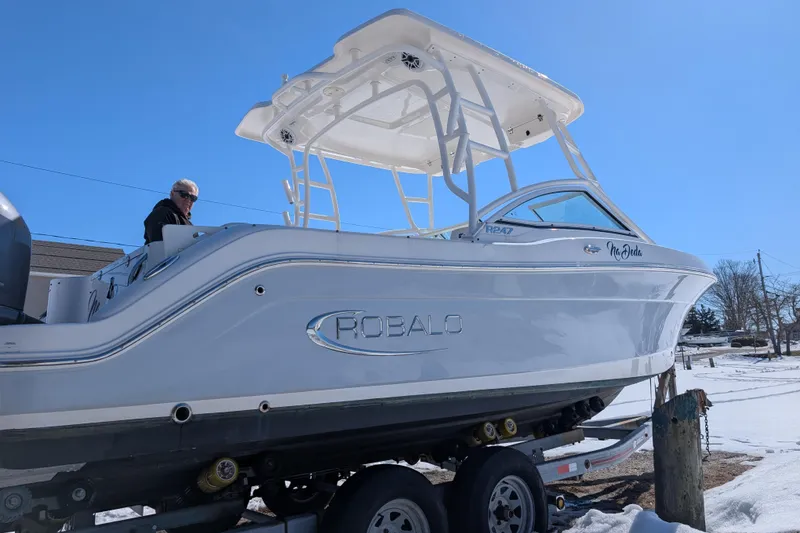 Slide: The Image of 2021 Robalo R247 Dual Console boat on trailer, side view in snowy setting. - 5