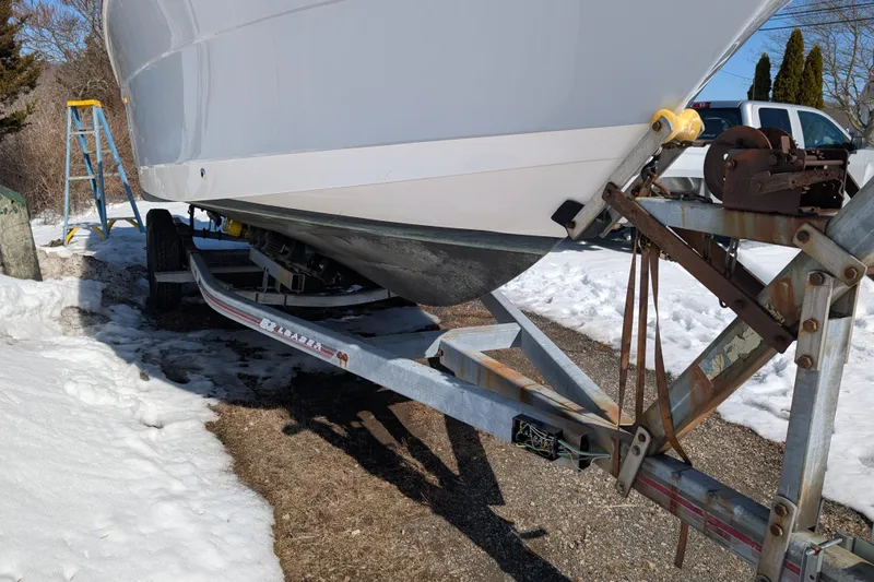 Slide: The Image of 2021 Robalo R247 Dual Console boat on trailer in snowy outdoor setting. - 6