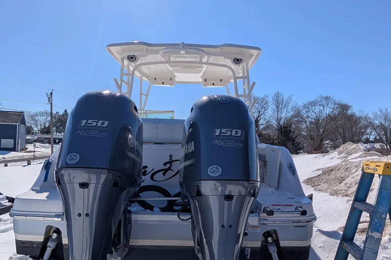Slide: The Image of 2021 Robalo R247 Dual Console with twin Yamaha 150 outboard engines in snowy setting. - 7